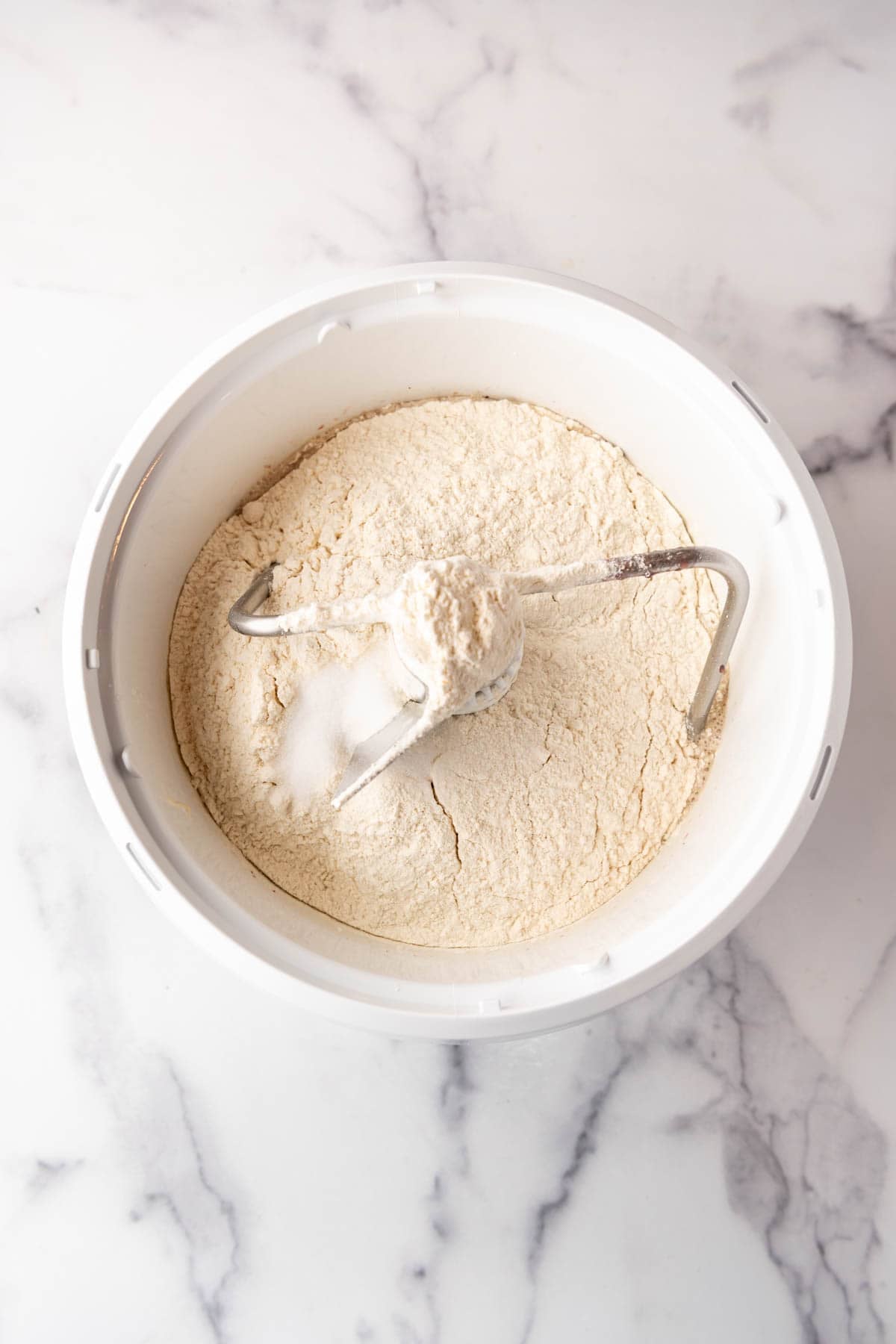 Adding flour and salt to a mixture.