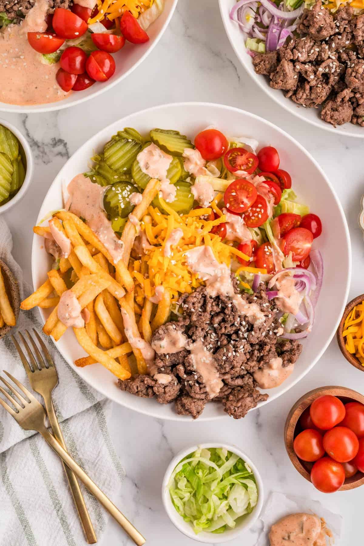 An overhead image of a burger bowl with ingredients around it.