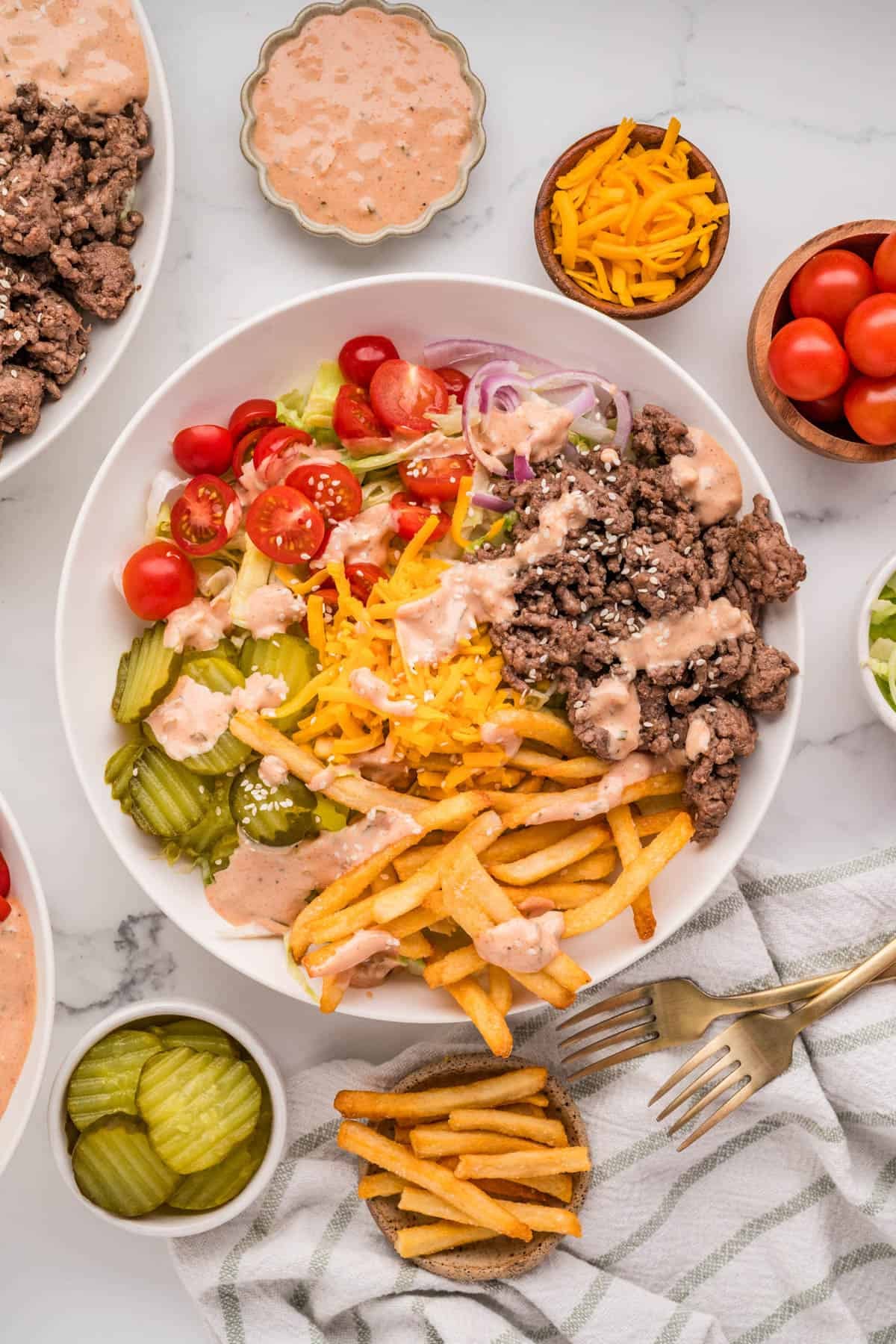 An overhead image of a burger bowl with fries.