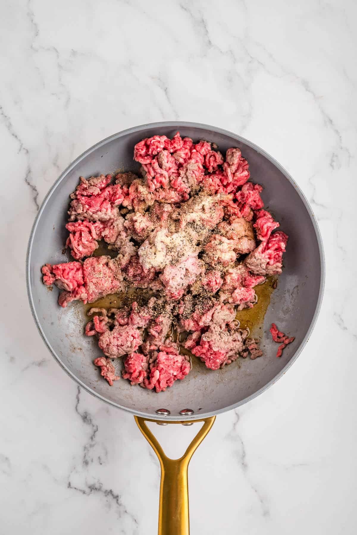 Seasoned ground beef in a skillet.