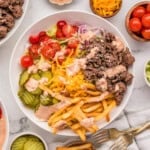 An overhead image of a burger bowl with fries.