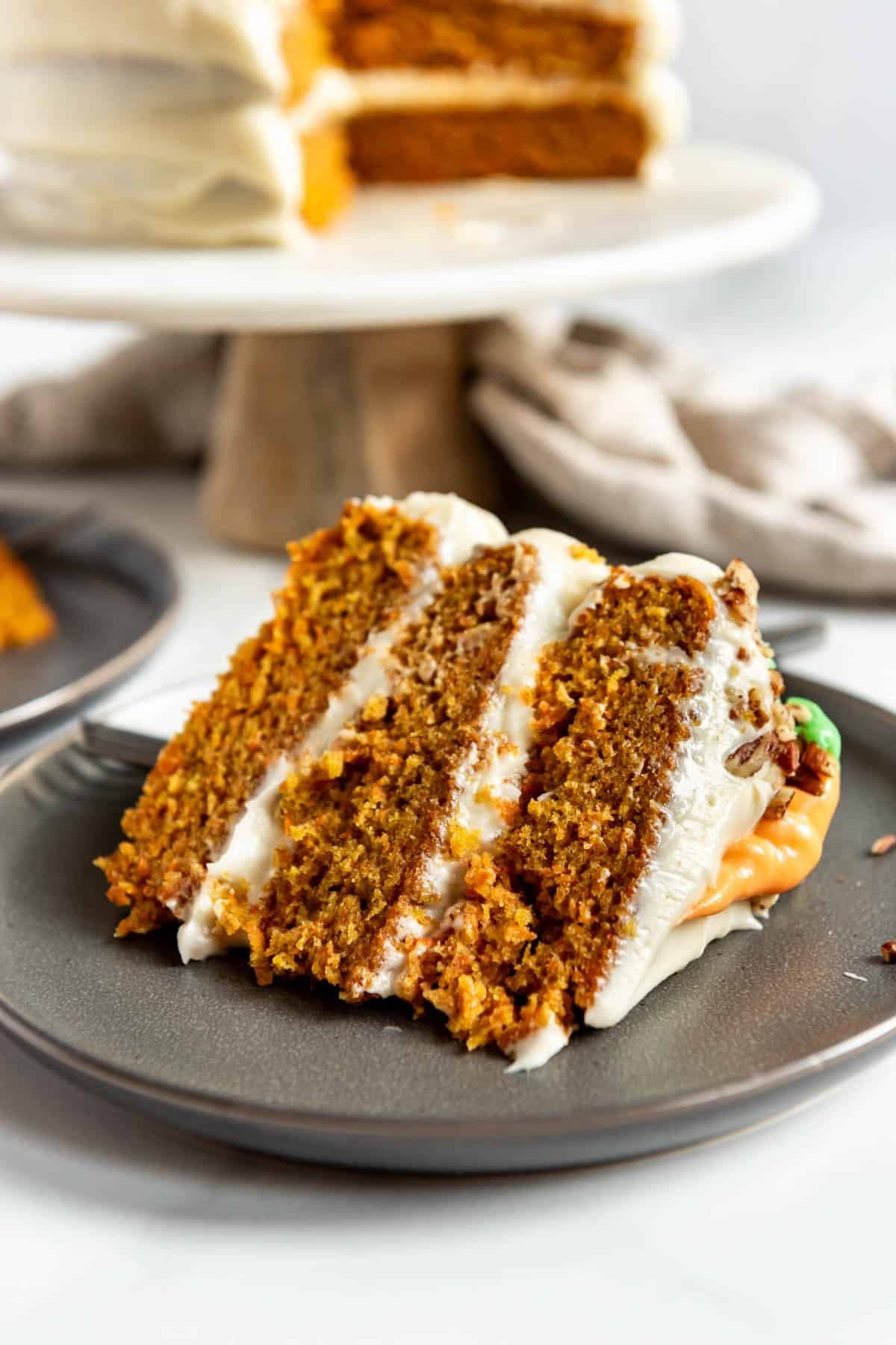 A slice of homemade carrot cake on a grey plate.