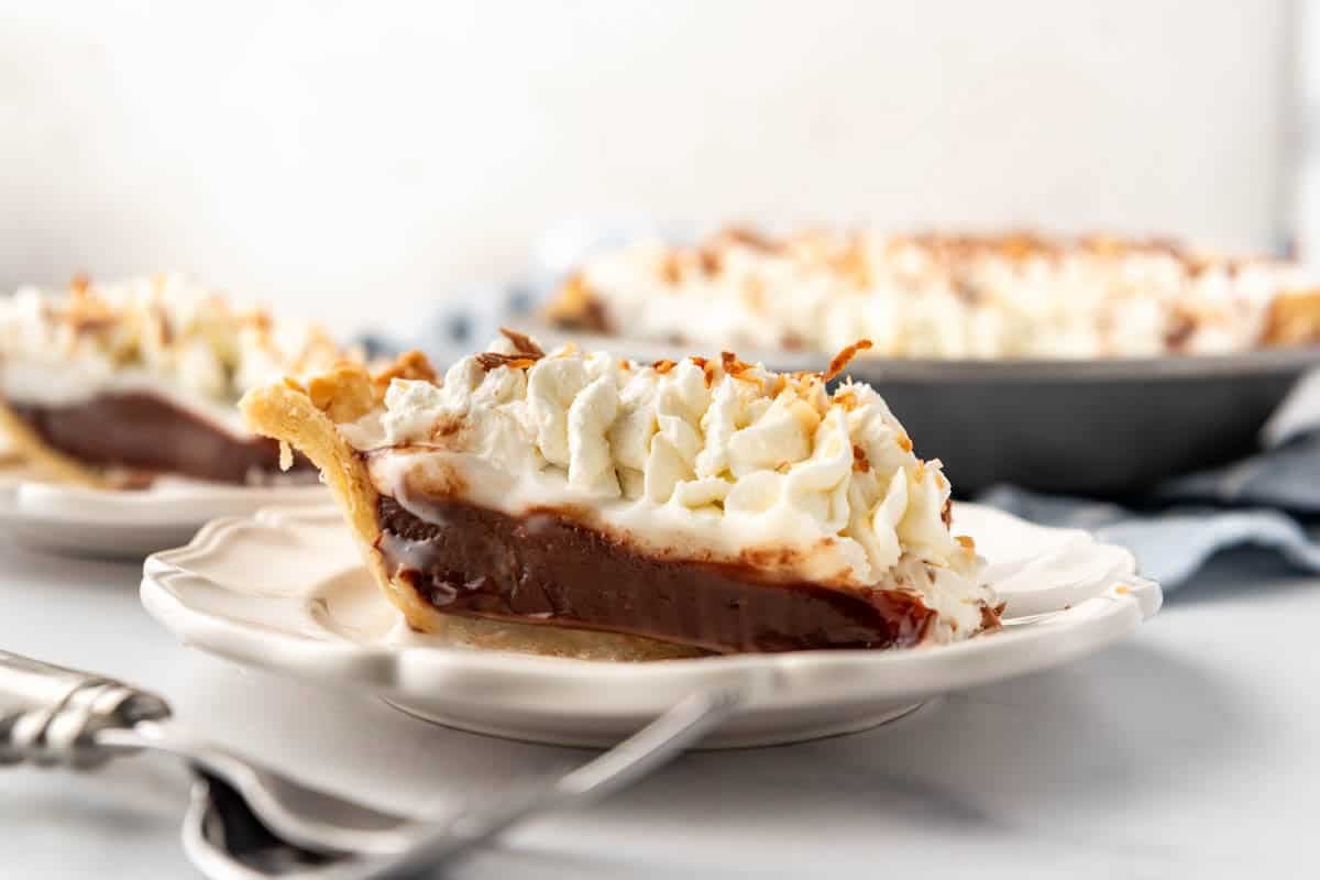 A slice of haupia pie on a white plate.
