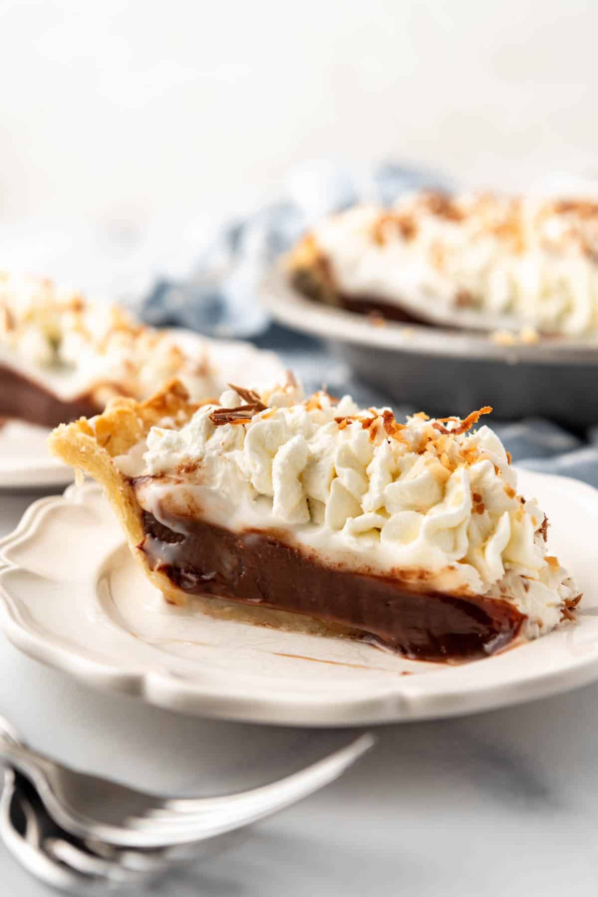 A slice of haupia pie on a white plate.