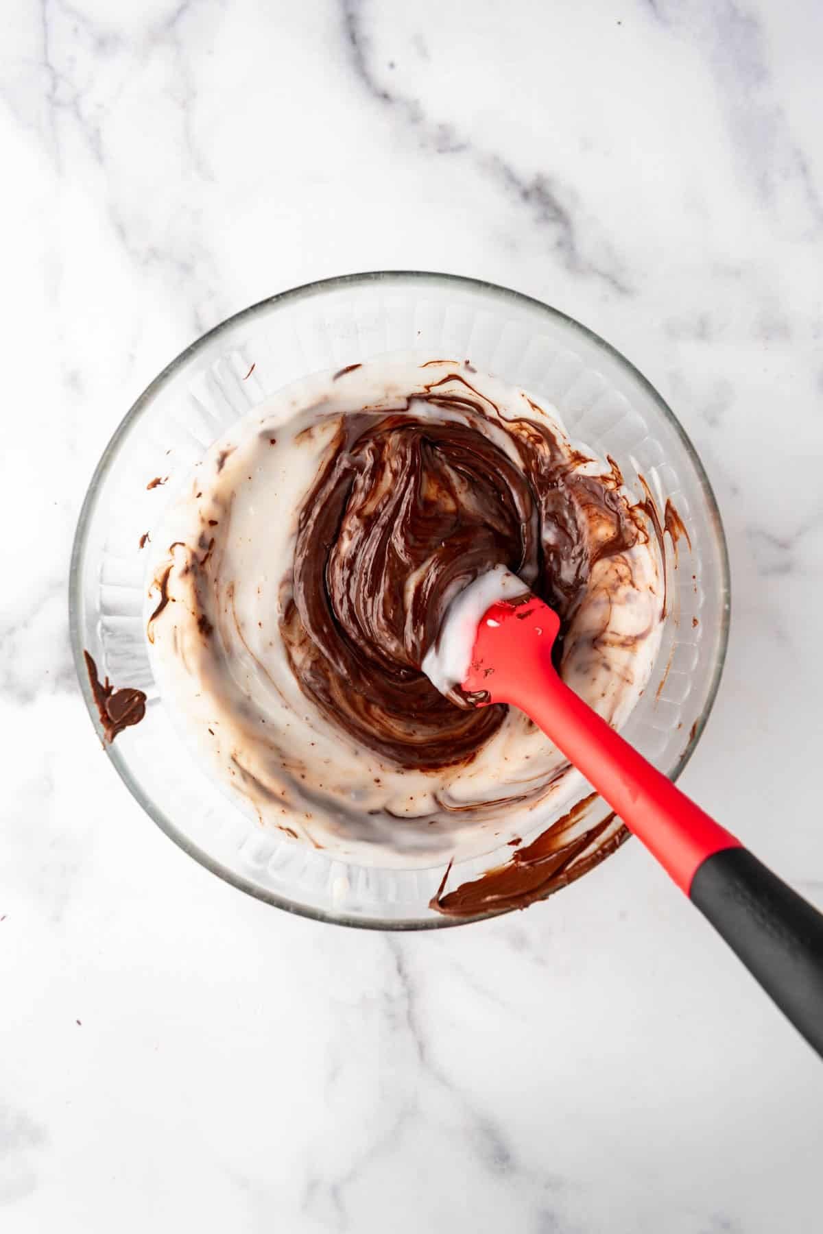 Stirring coconut pudding mixture into melted chocolate.