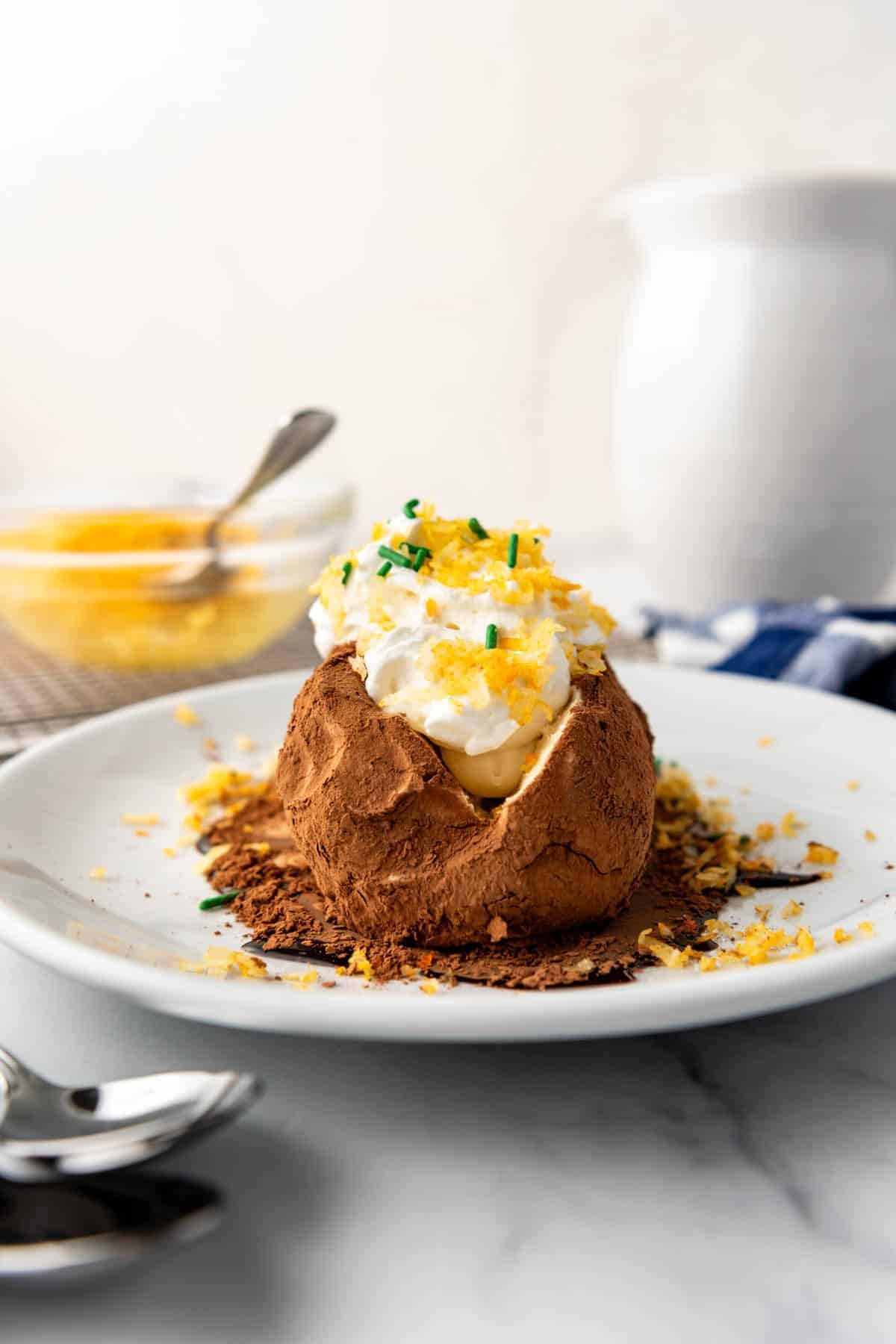 An ice cream "baked potato" topped with whipped cream instead of sour cream with orange-dyed shredded coconut for "cheese" and green sprinkles for "chives".