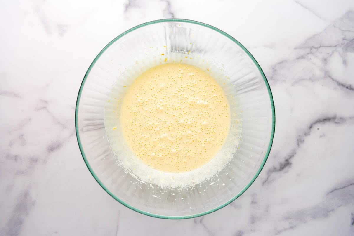 Whisked eggs, sugar, and olive oil in a bowl.