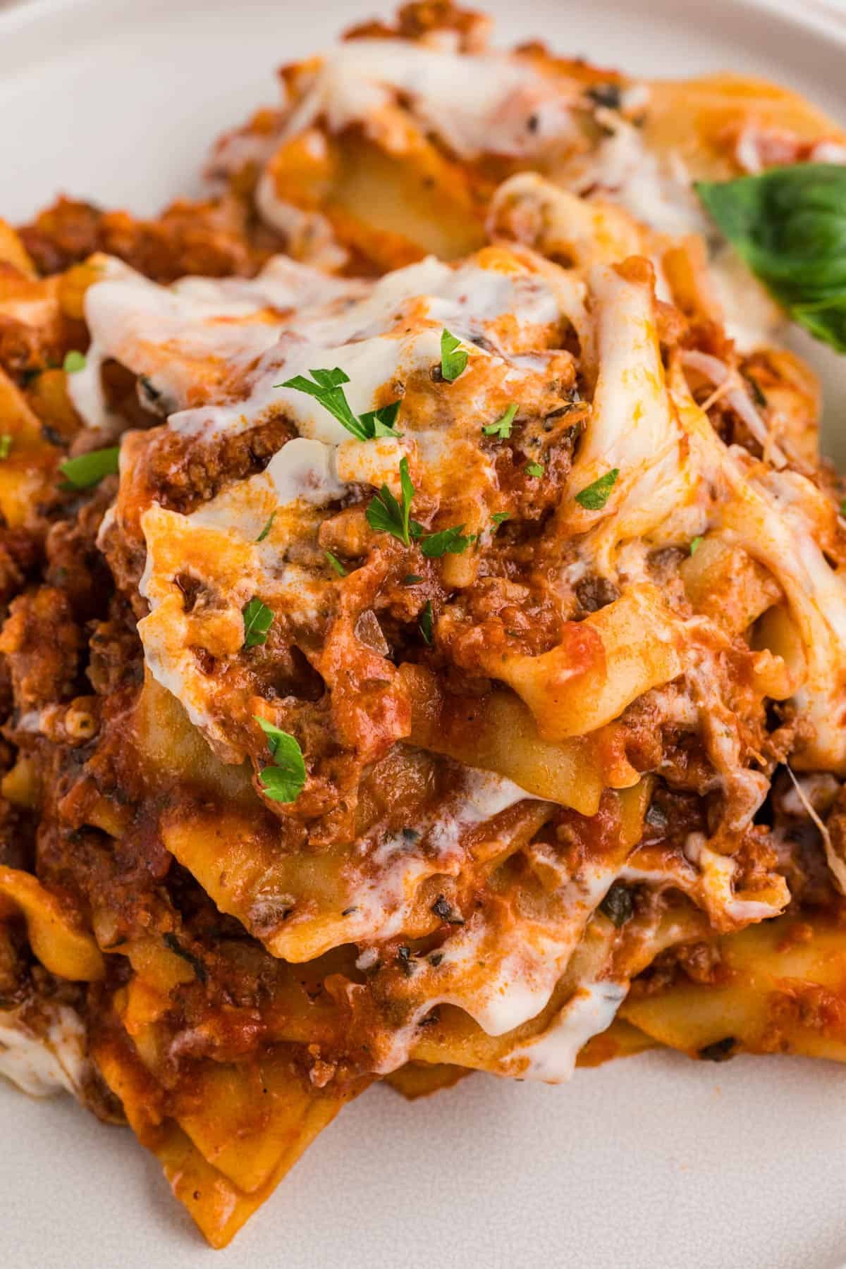 A close up image of skillet lasagna on a white plate.