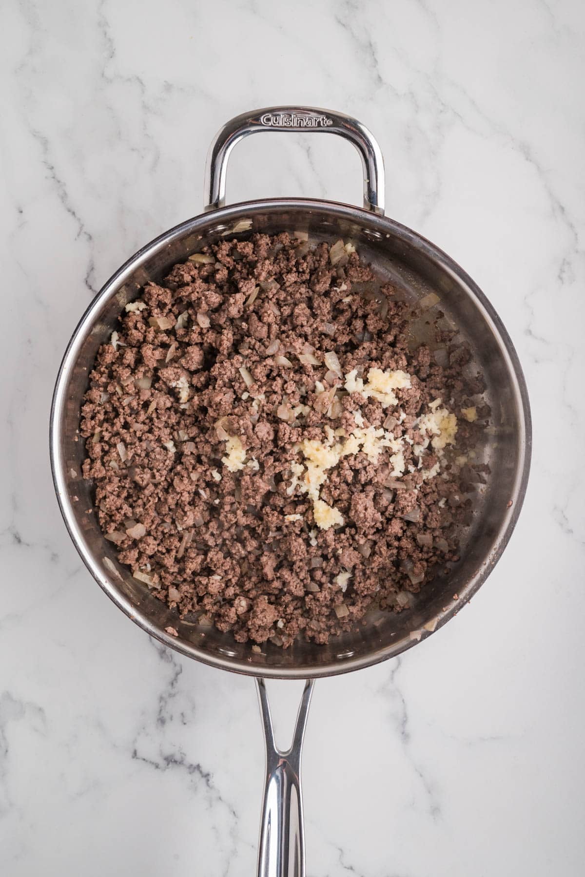 Browned ground beef in a skillet.