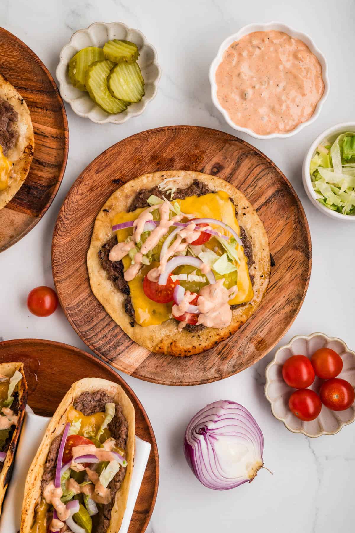 An overhead image of a smash burger taco on a wooden plate.