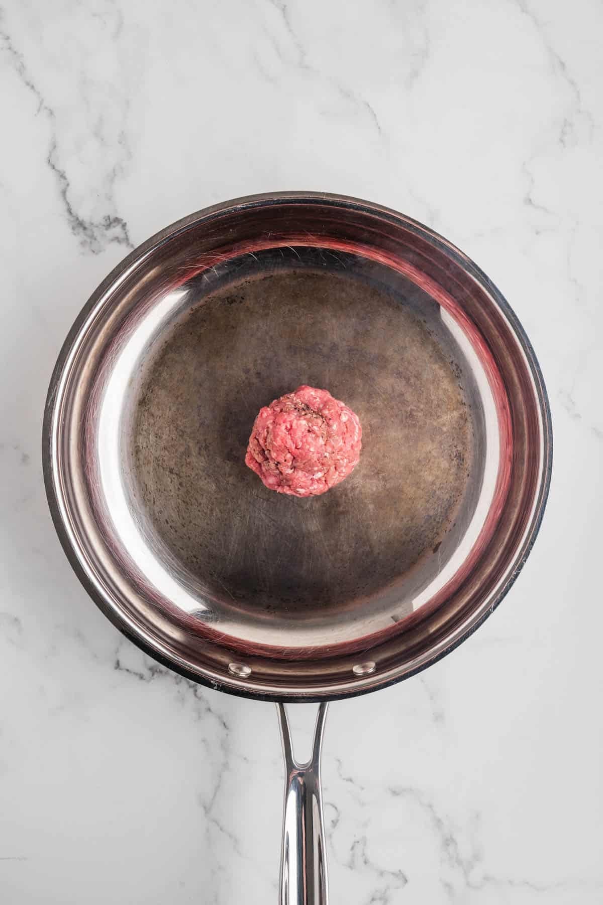A meatball in a large skillet.