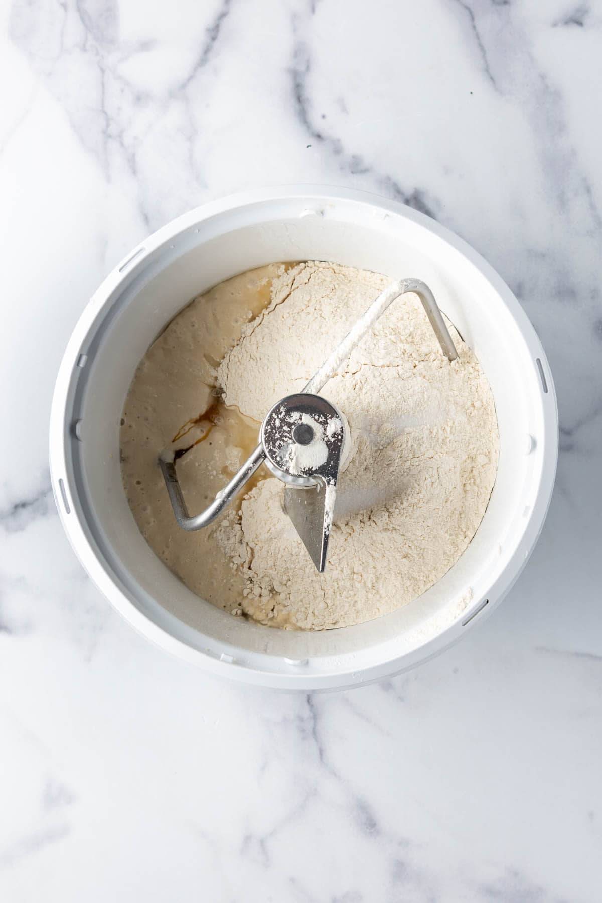 Sourdough bread dough ingredients in a Bosch mixer.