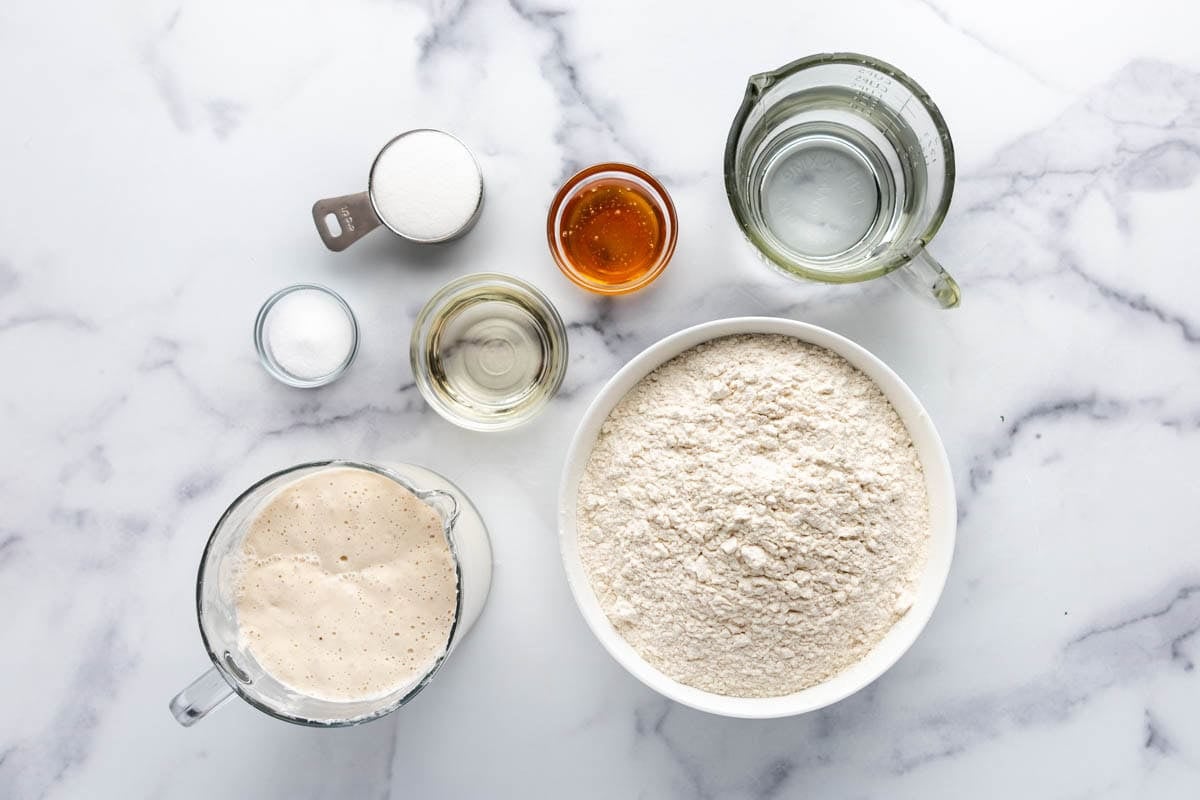An overhead image of ingredients for making soft sourdough sandwich bread.