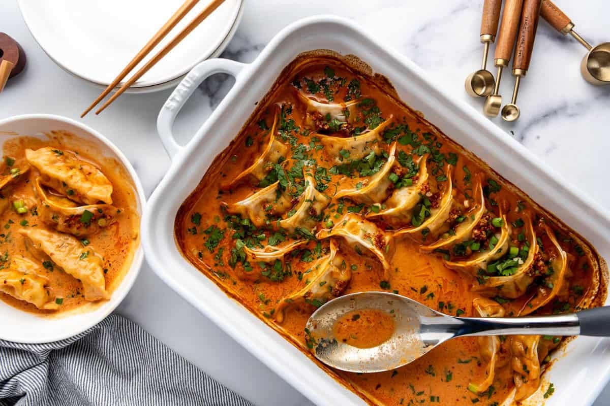 An overhead image of a casserole dish of baked dumplings with a serving spoon in it.