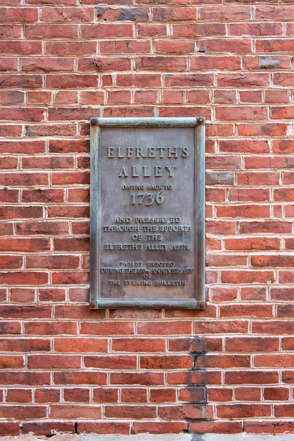 An image of a plaque designating Elfreth's Alley on a brick wall.