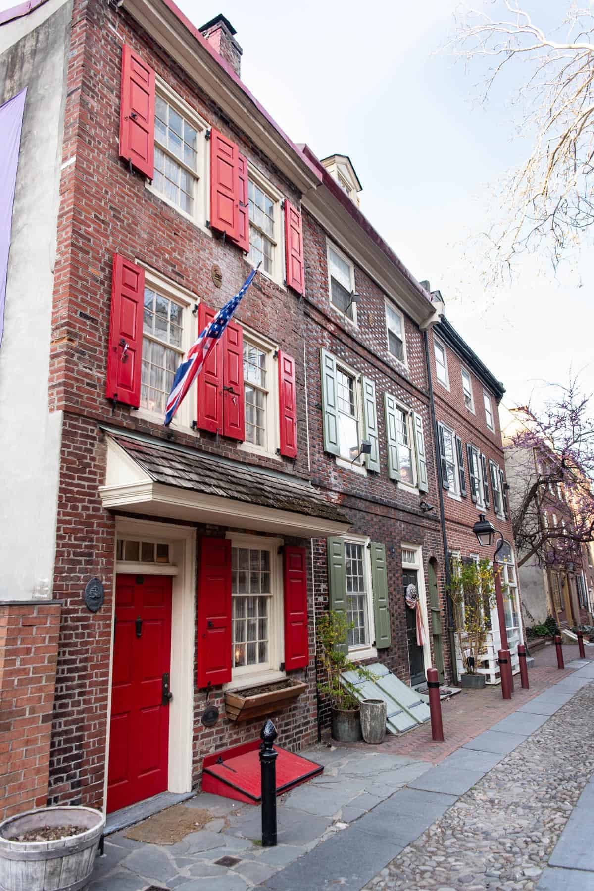 An image of a historic house at the end of Elfreth's Alley with red shutters and doors.