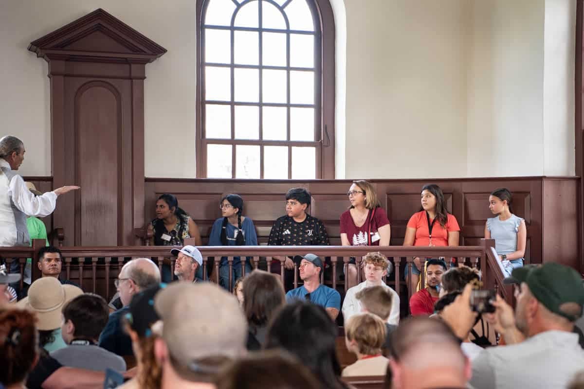 People sitting in the jury seats in the courthouse at Colonial Williamsburg for a mock trial.