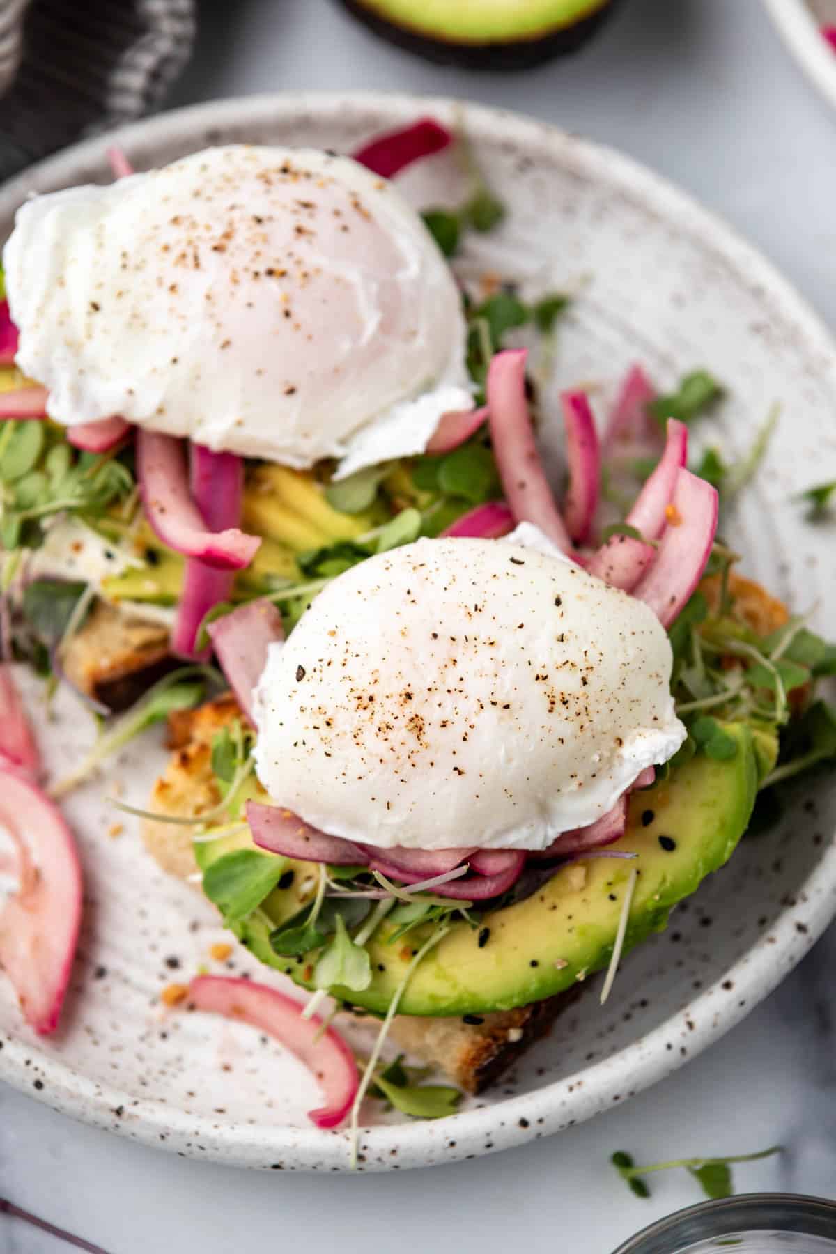 A close up image of poached eggs on top of avocado toast.