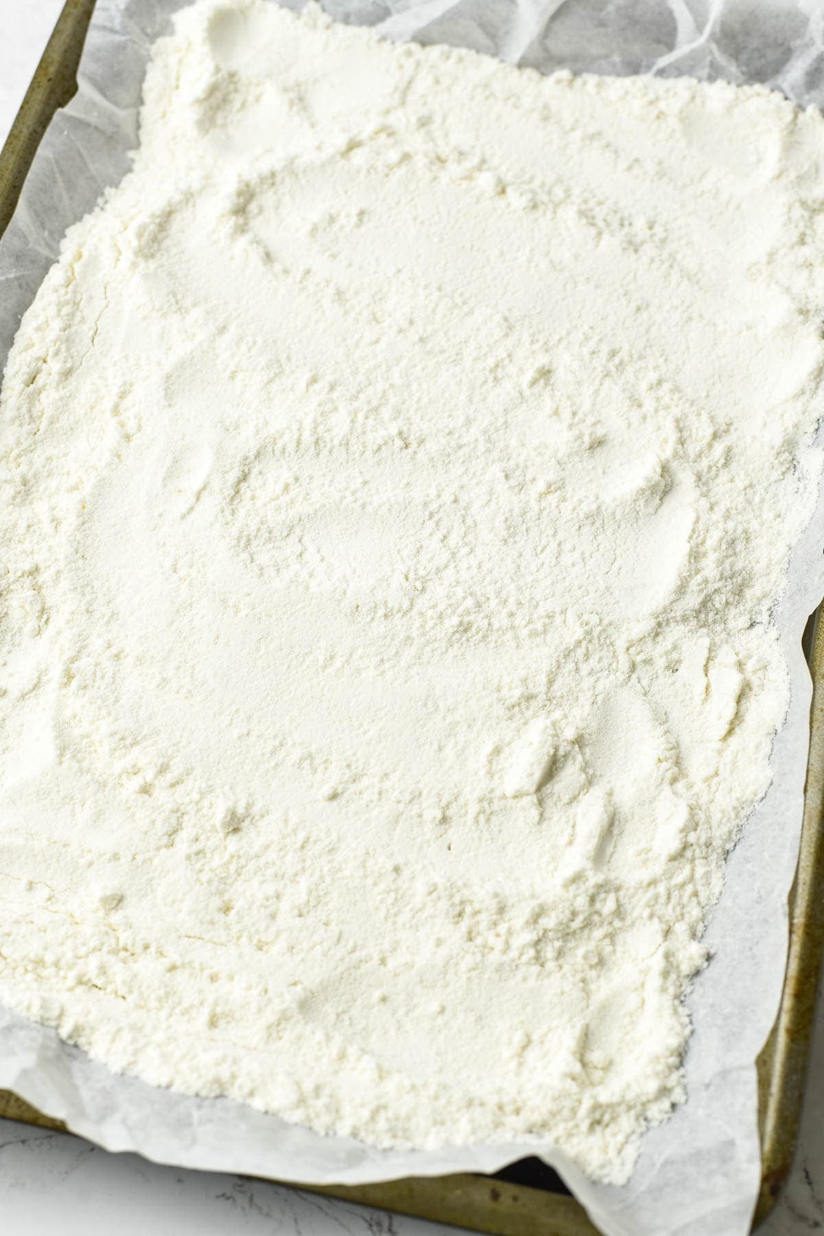 Spreading cake mix onto a baking sheet.