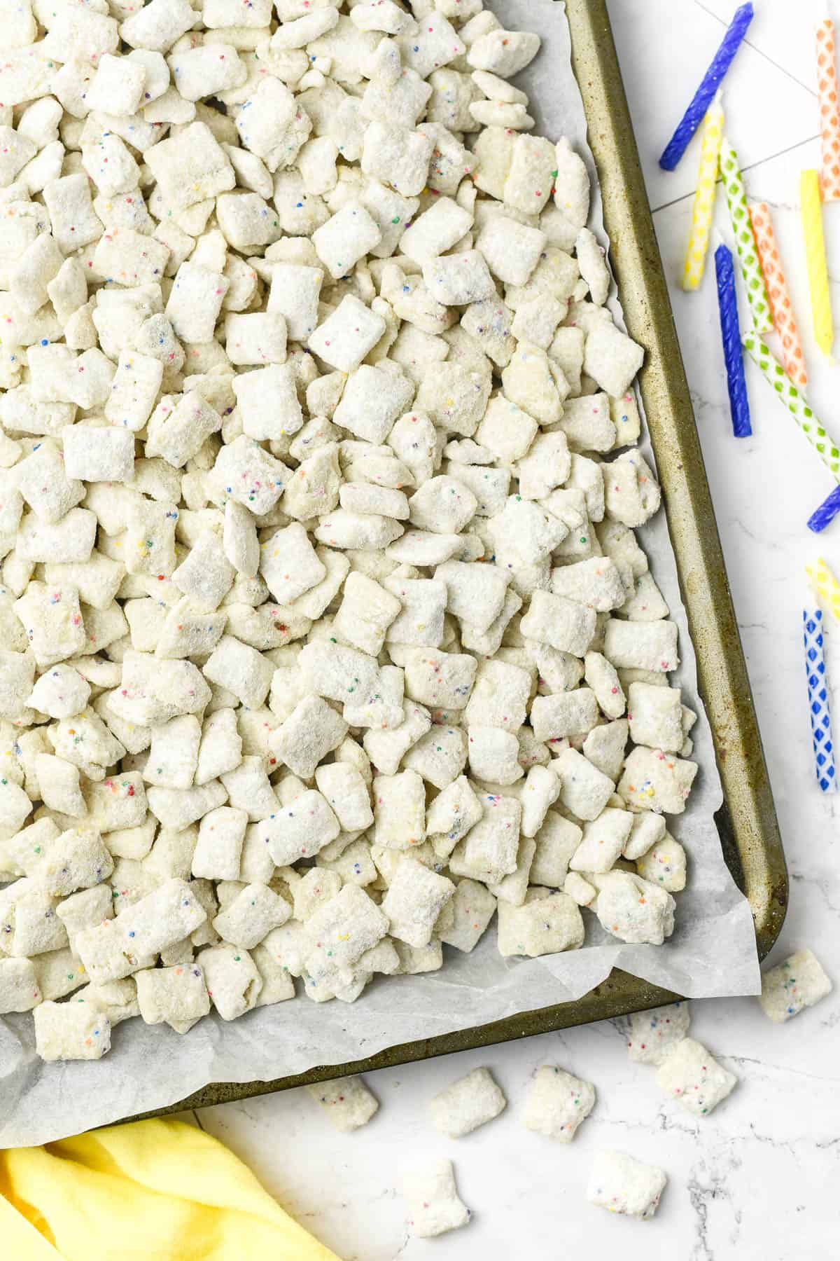 An overhead image of a large sheet pan covered with cake batter puppy chow.