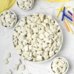 Bowls of cake batter puppy chow next to birthday candles.