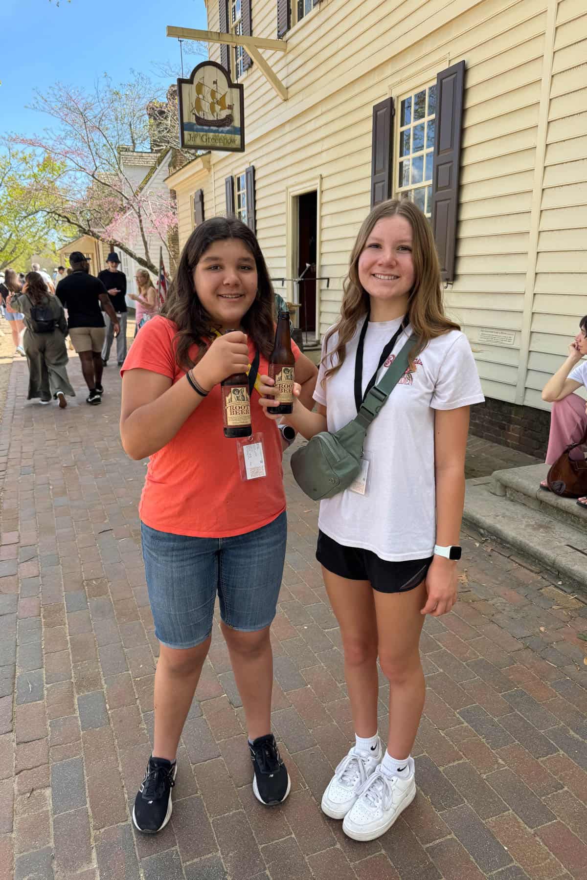 Two girls holding root beers in Colonial Williamsburg.