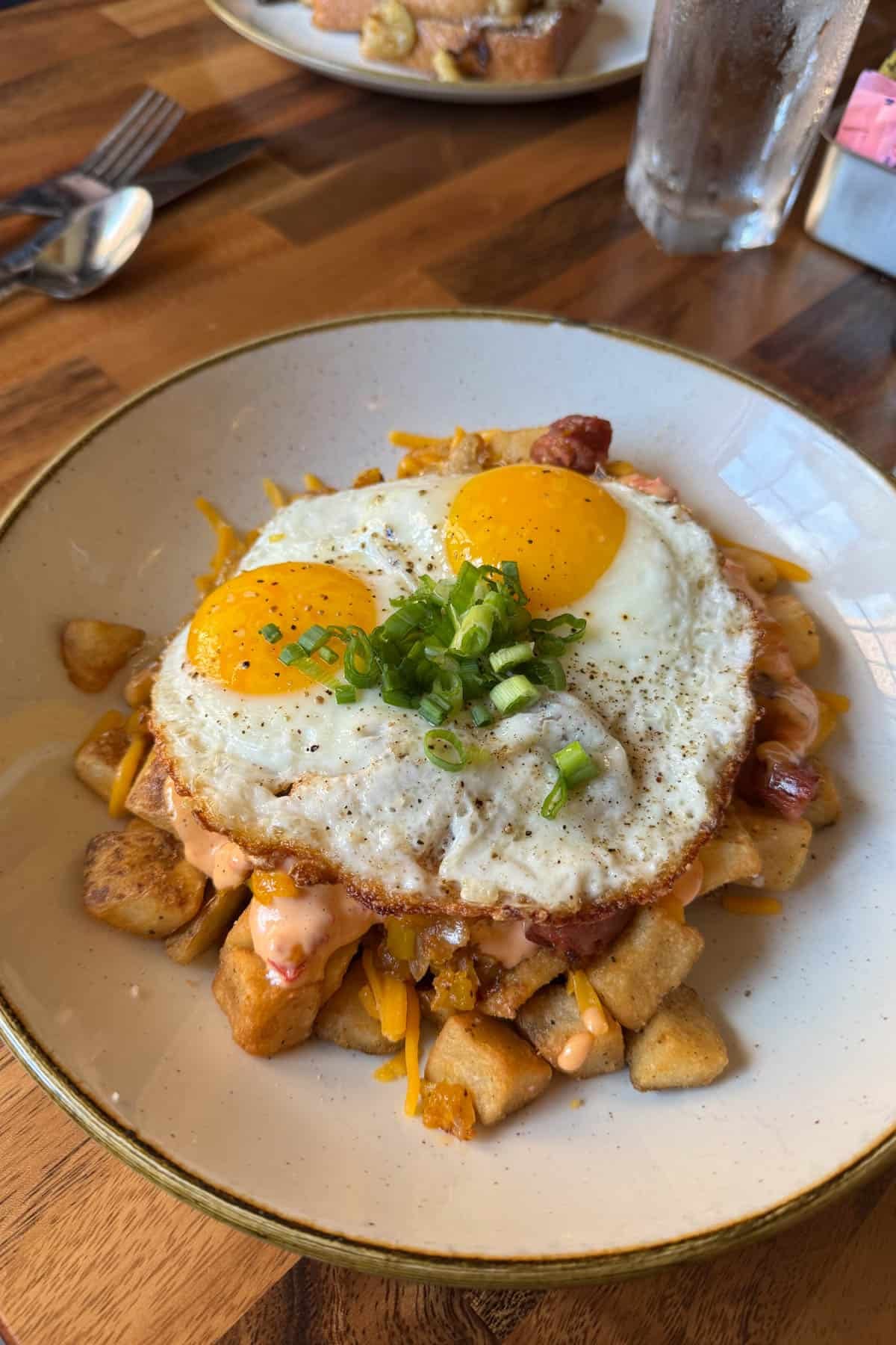 A plate of breakfast hash with fried eggs on top.