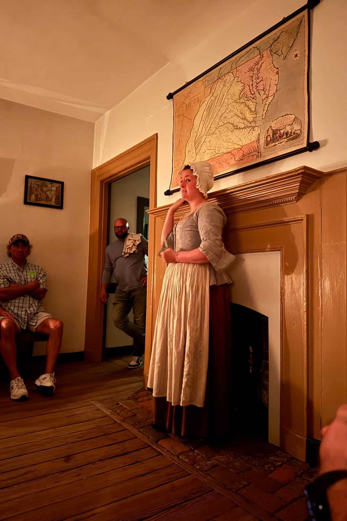 A woman in colonial dress leading a ghost tour in Colonial Williamsburg.