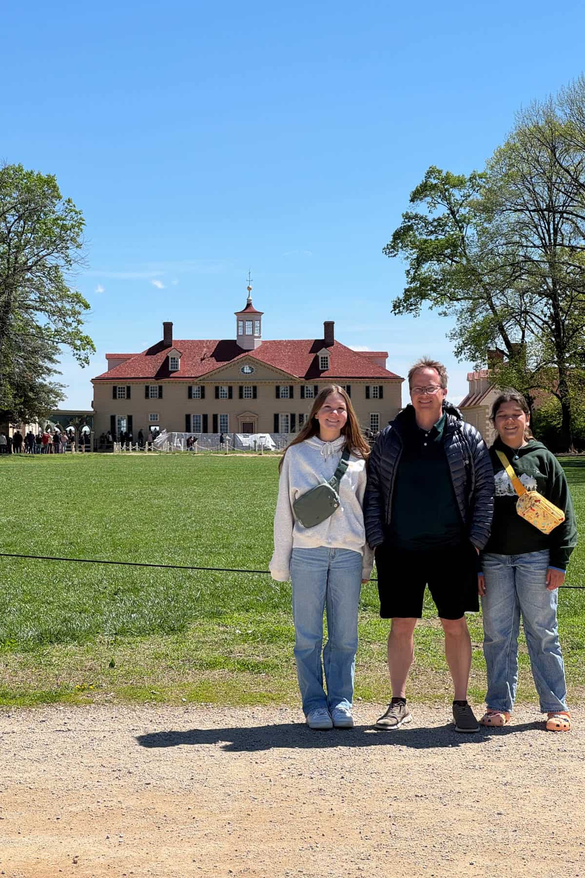 A dad and two daughters in front of Mount Vernon.