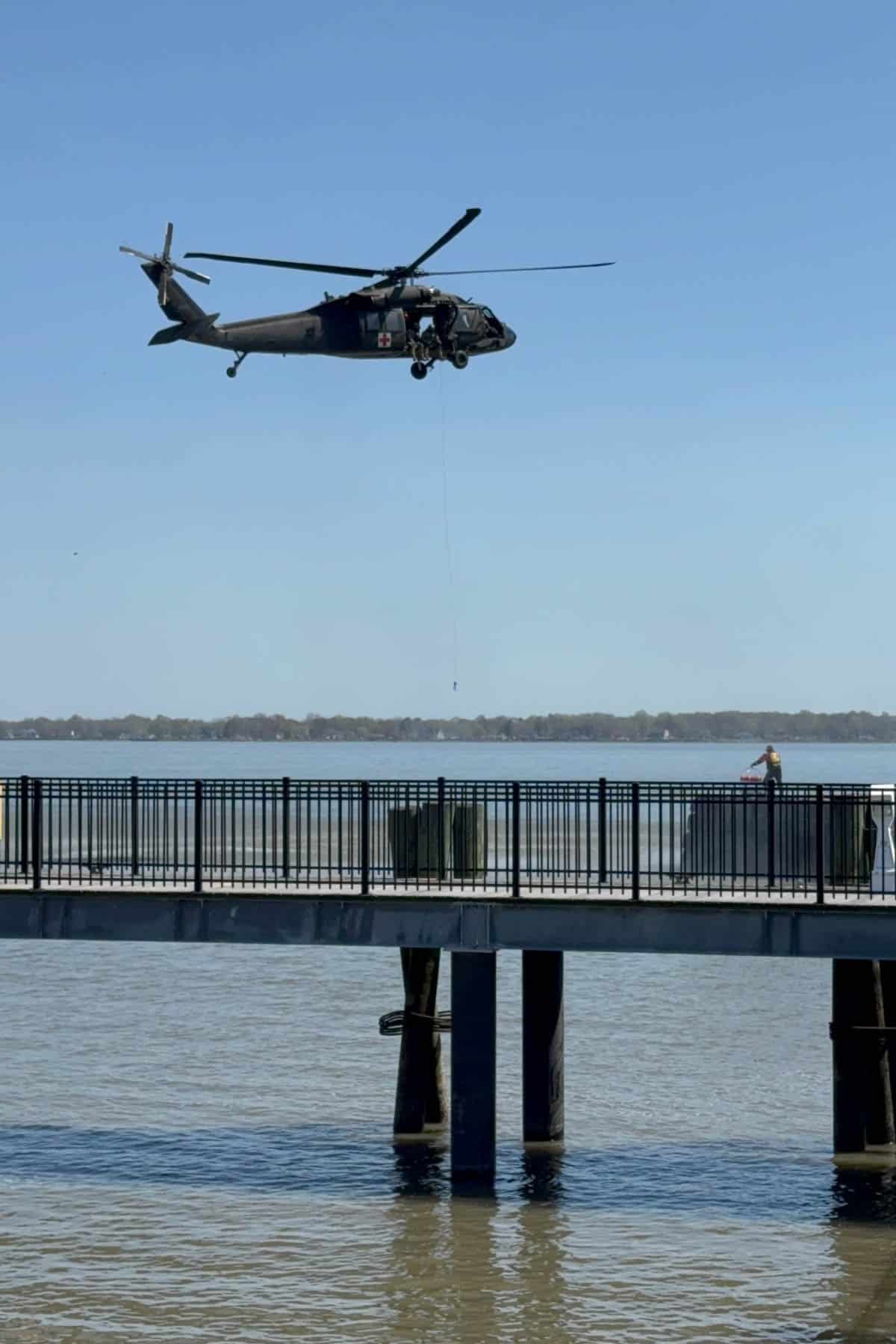 An image of a helicopter hovering over the Delaware River with a line extended to a rescue worker below.