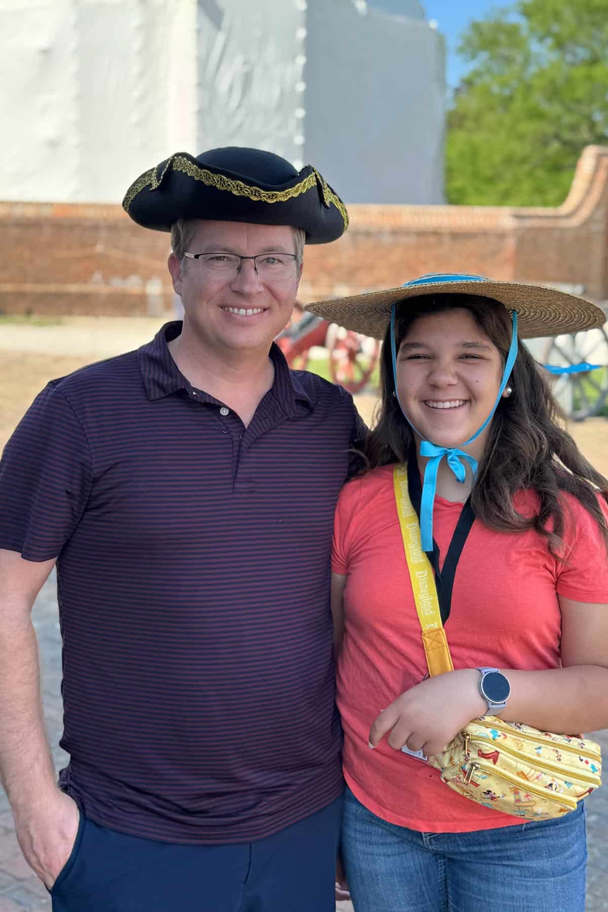 A dad and daughter wearing colonial hats.