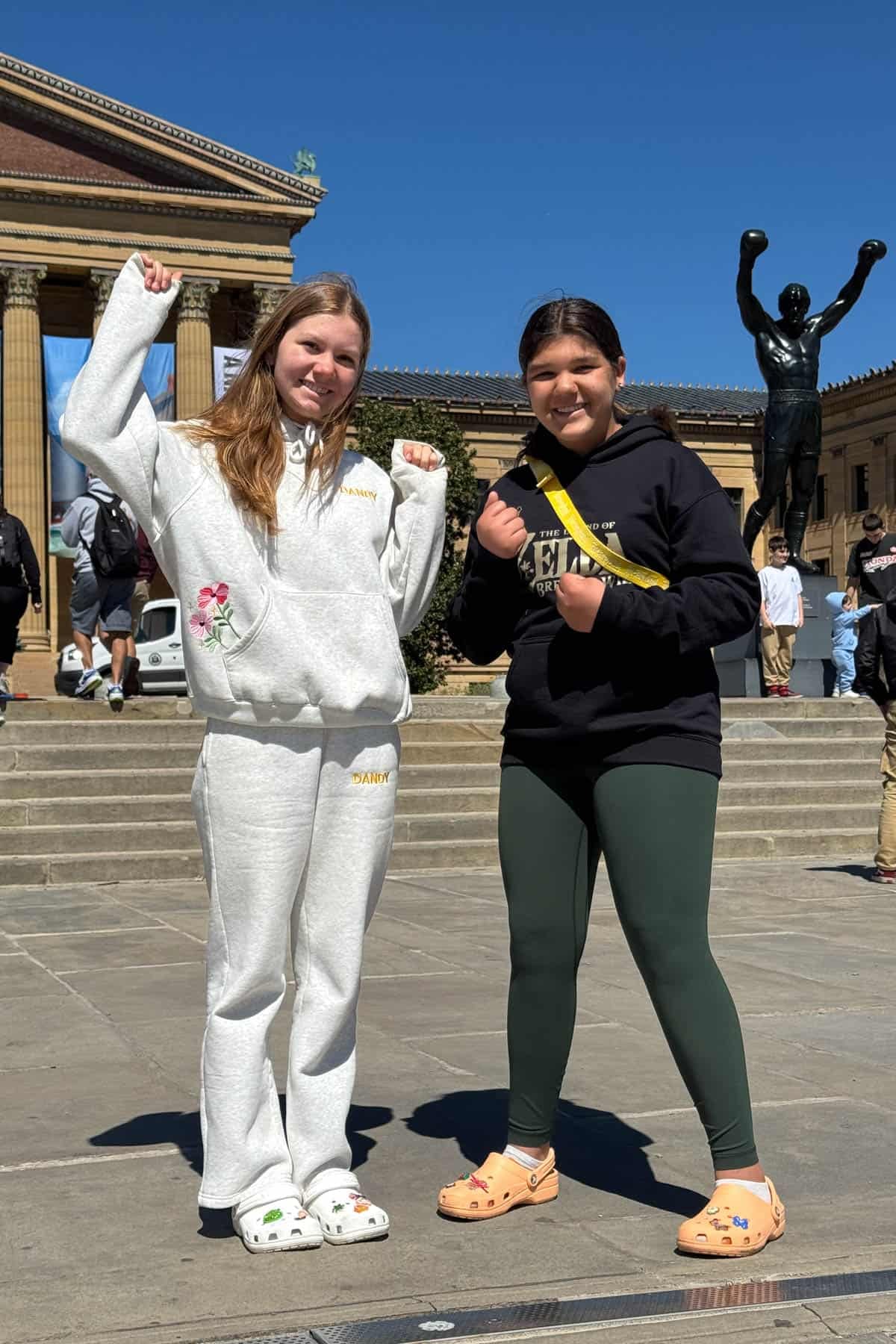 Two girls in front of the Rocky statue in Philadelphia.