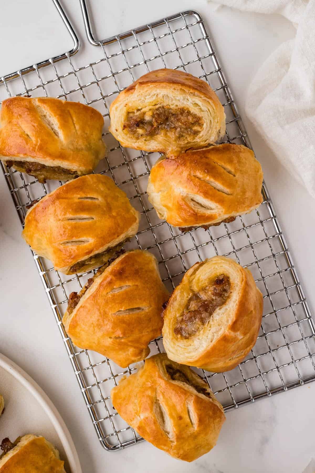 Sausage rolls on a wire rack.