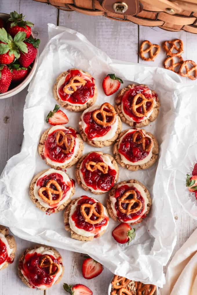 An overhead image of strawberry pretzel cookies on white parchment paper.