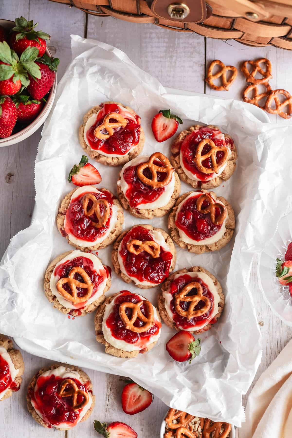 An overhead image of strawberry pretzel cookies on white parchment paper.