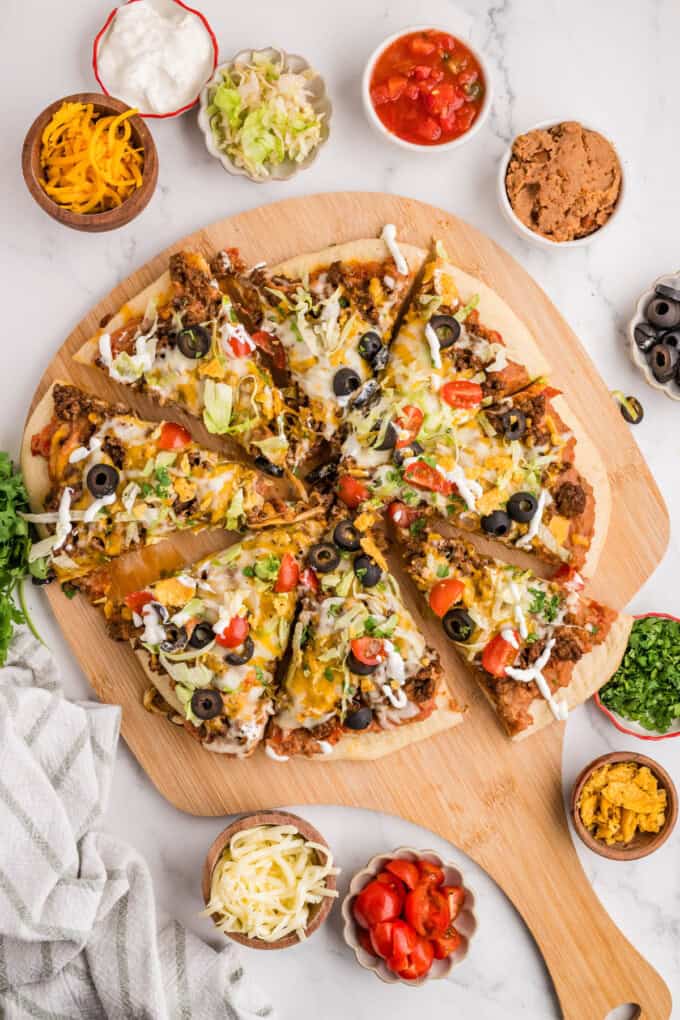 An overhead image of a finished taco pizza on a pizza peel.