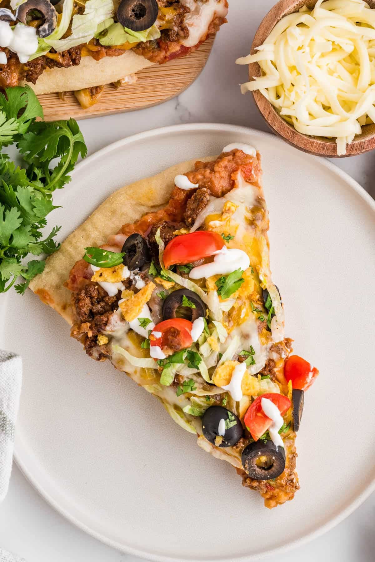A slice of taco pizza on a plate.
