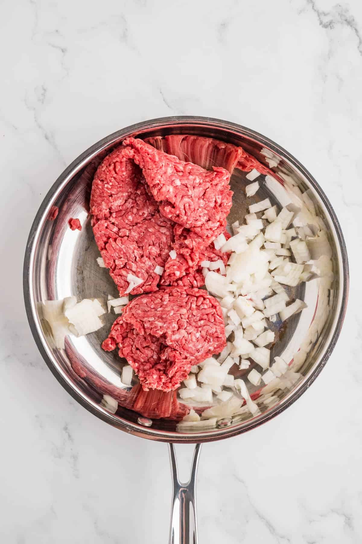 Ground beef and onions in a skillet.