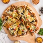 An overhead image of a sliced taco pizza.