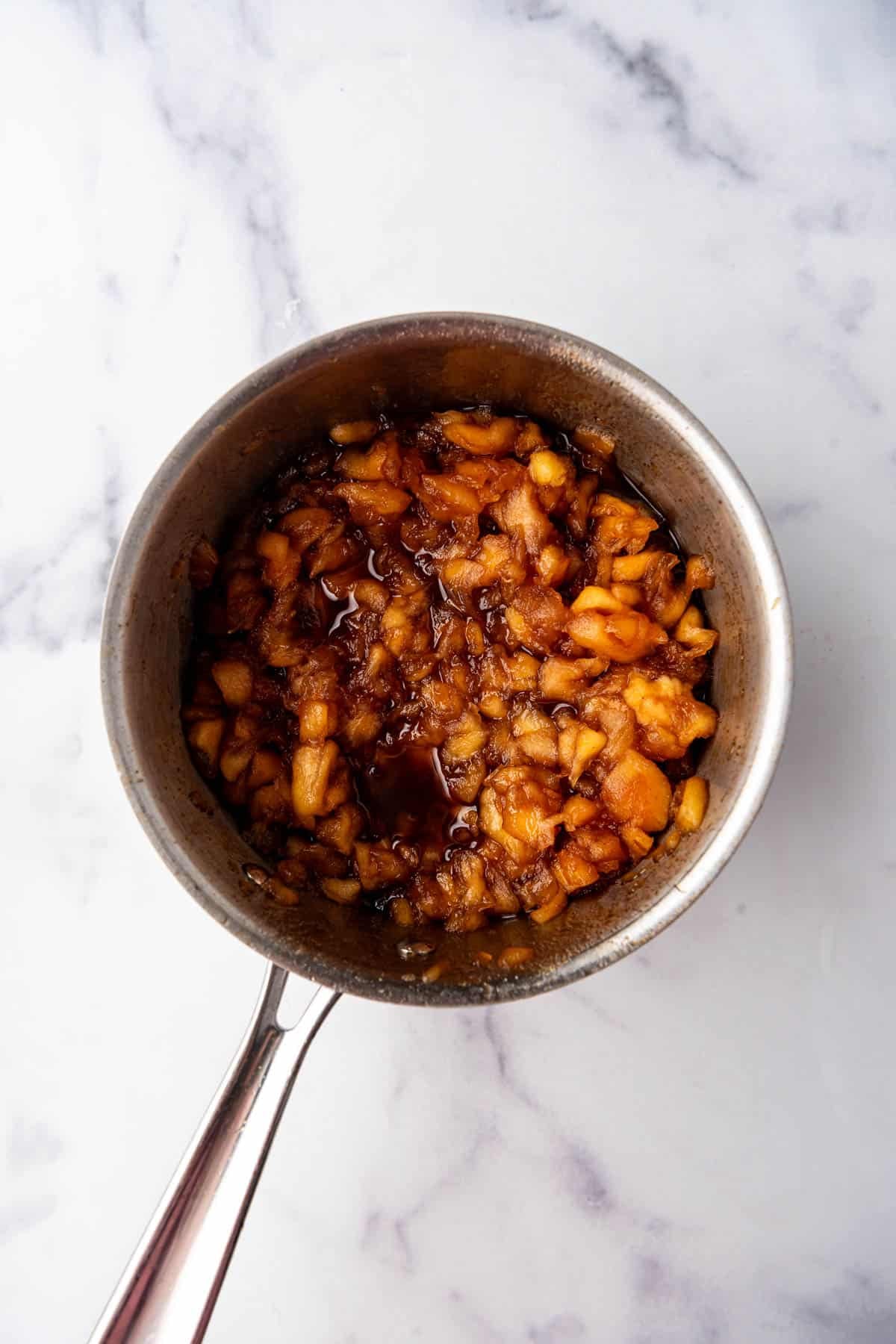 Cooked apple filling in a saucepan.