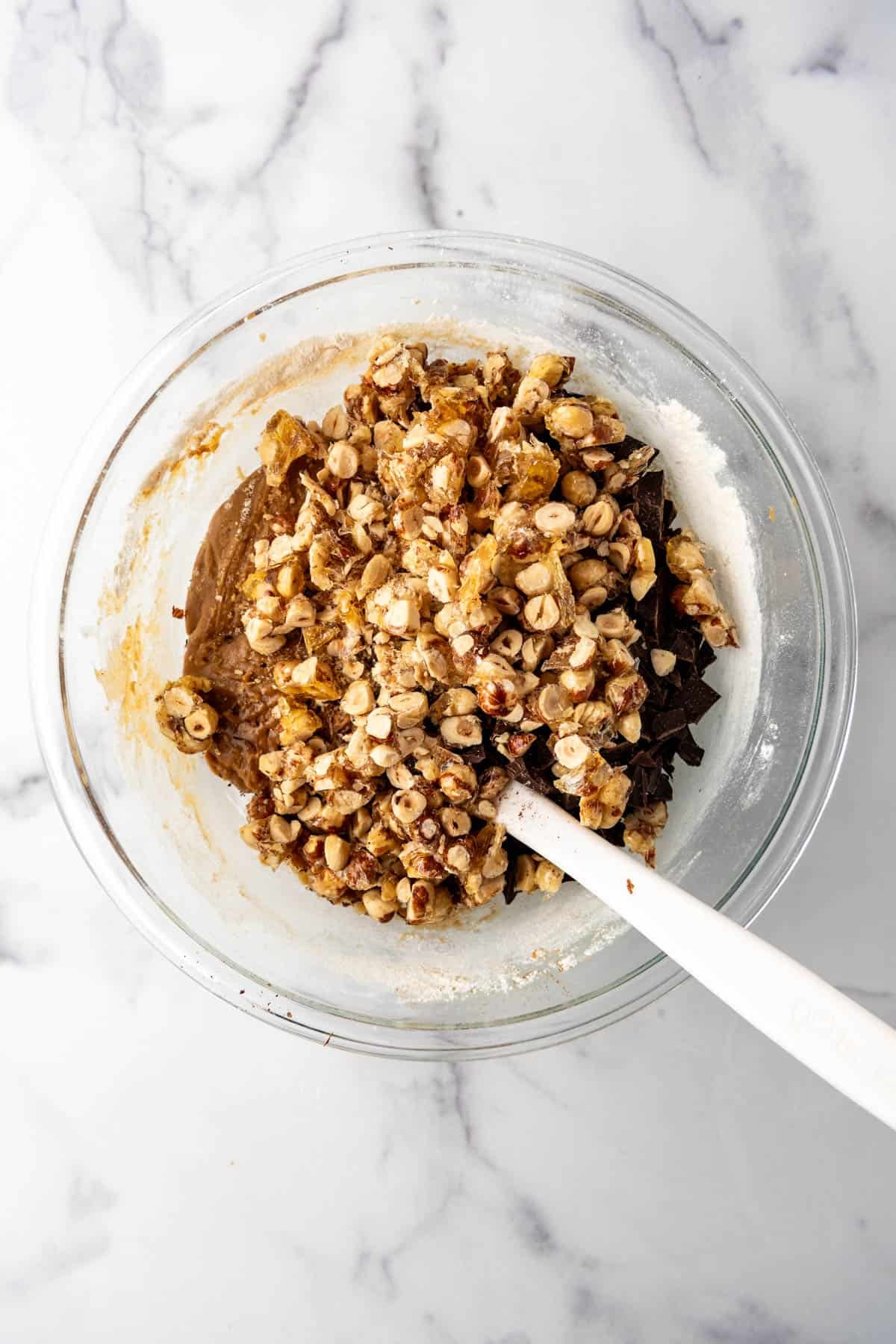 Adding chopped chocolate chunks and chopped candied hazelnut praline to cookie dough.