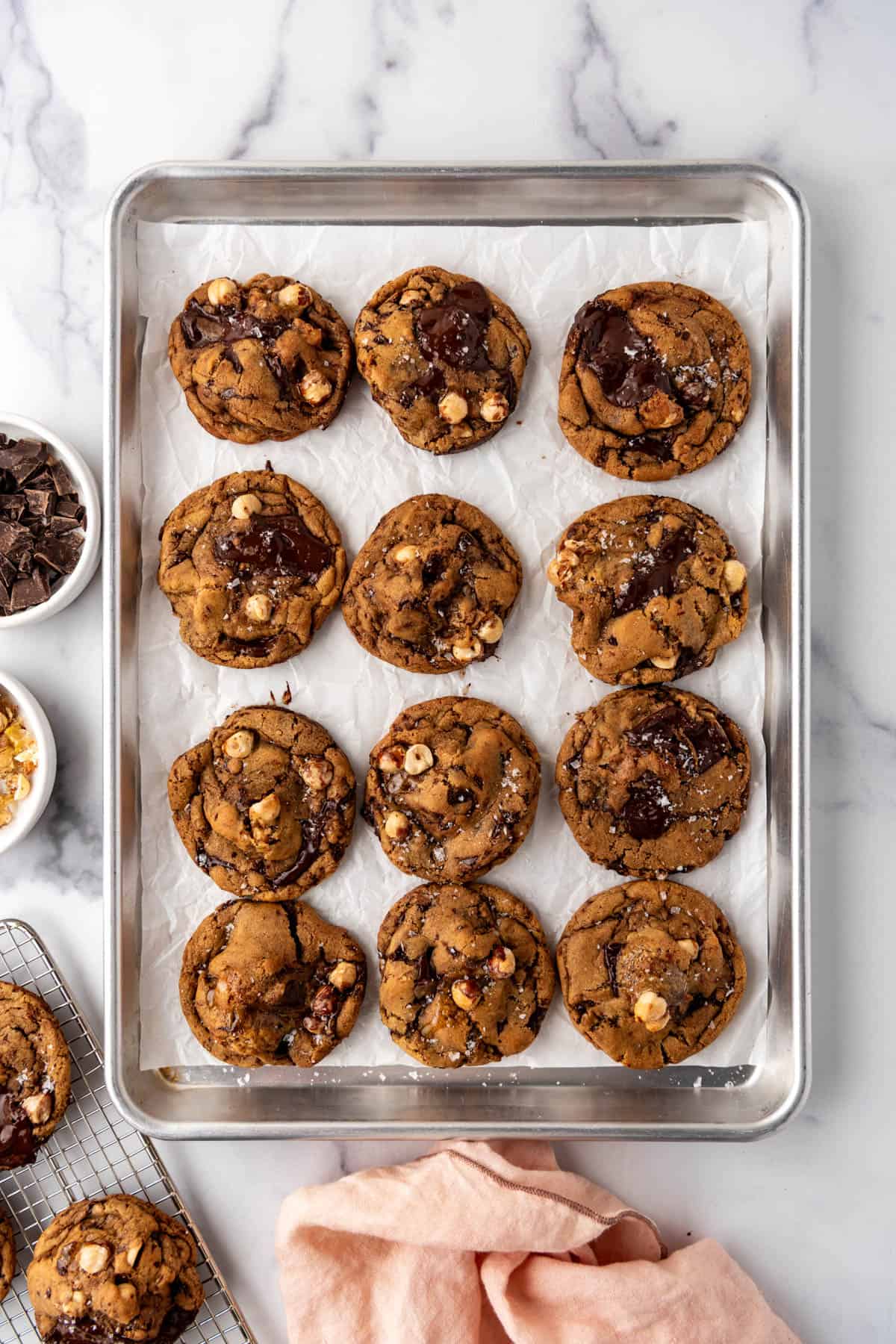 A baking sheet with brown butter hazelnut chunk cookies on it.