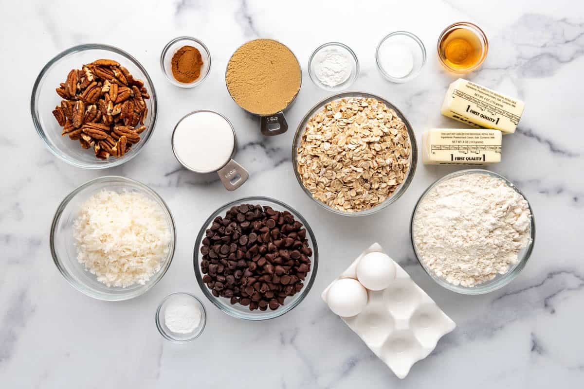Ingredients for making cowboy cookies on a white surface.