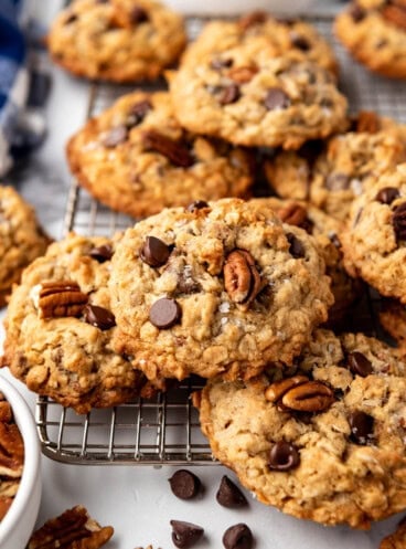 An image of cowboy cookies with chocolate chips and pecans on top.