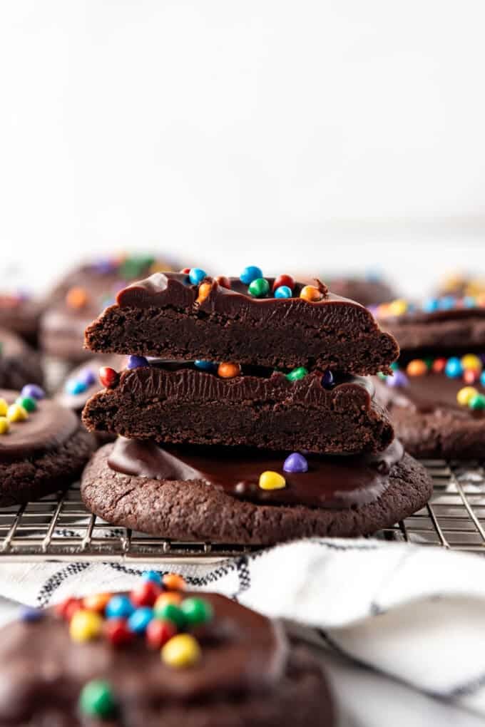 Stacked cosmic brownie cookies with the top ones sliced in half.
