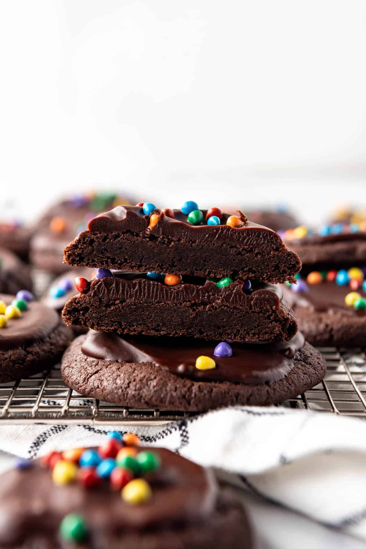 Stacked cosmic brownie cookies with the top ones sliced in half.