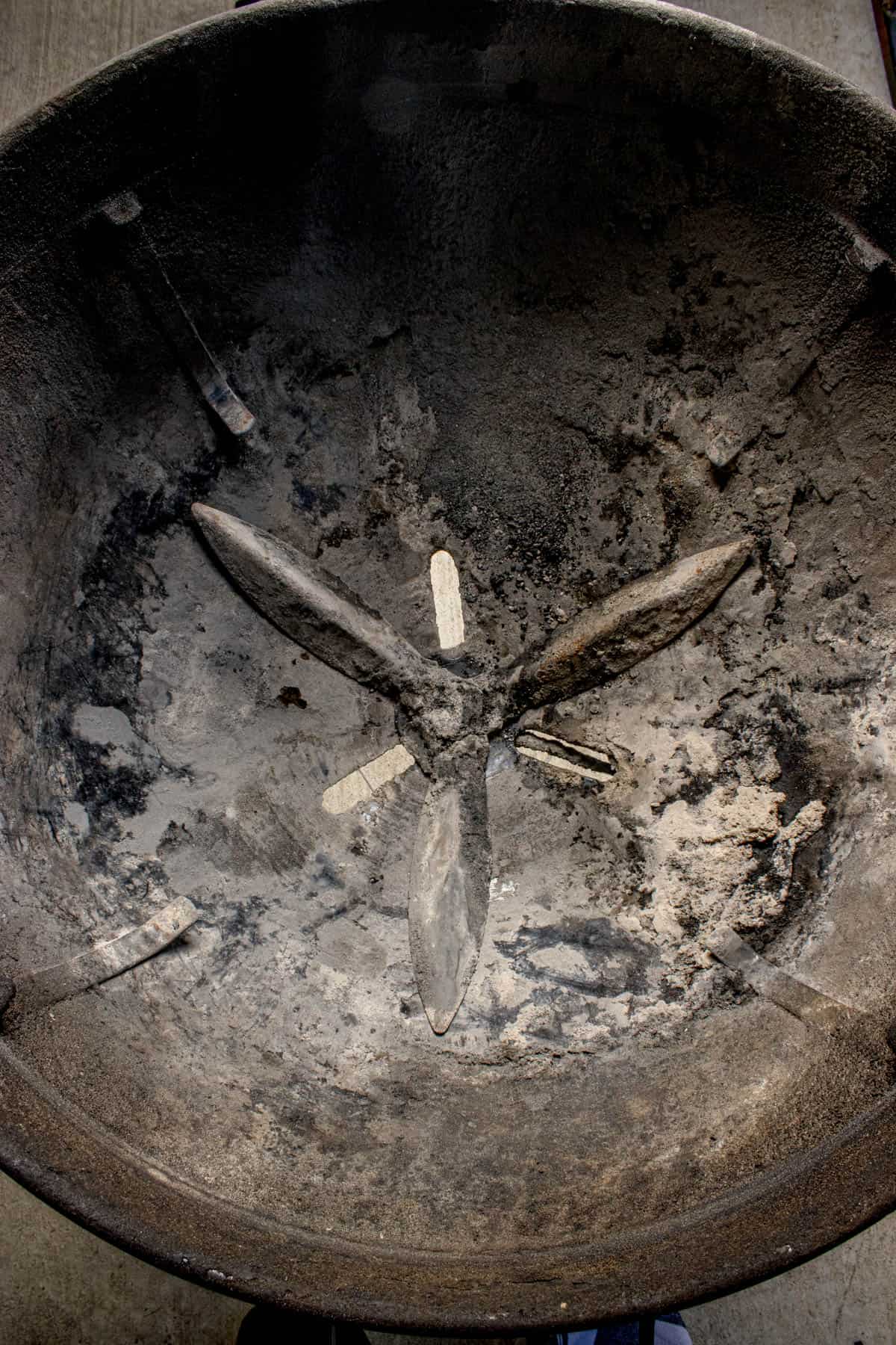 An image of old ash in the bottom of a charcoal grill.