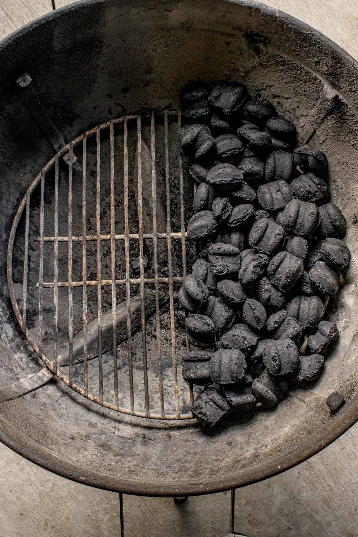 An image of charcoal pushed to one side of a charcoal grill for indirect grilling.