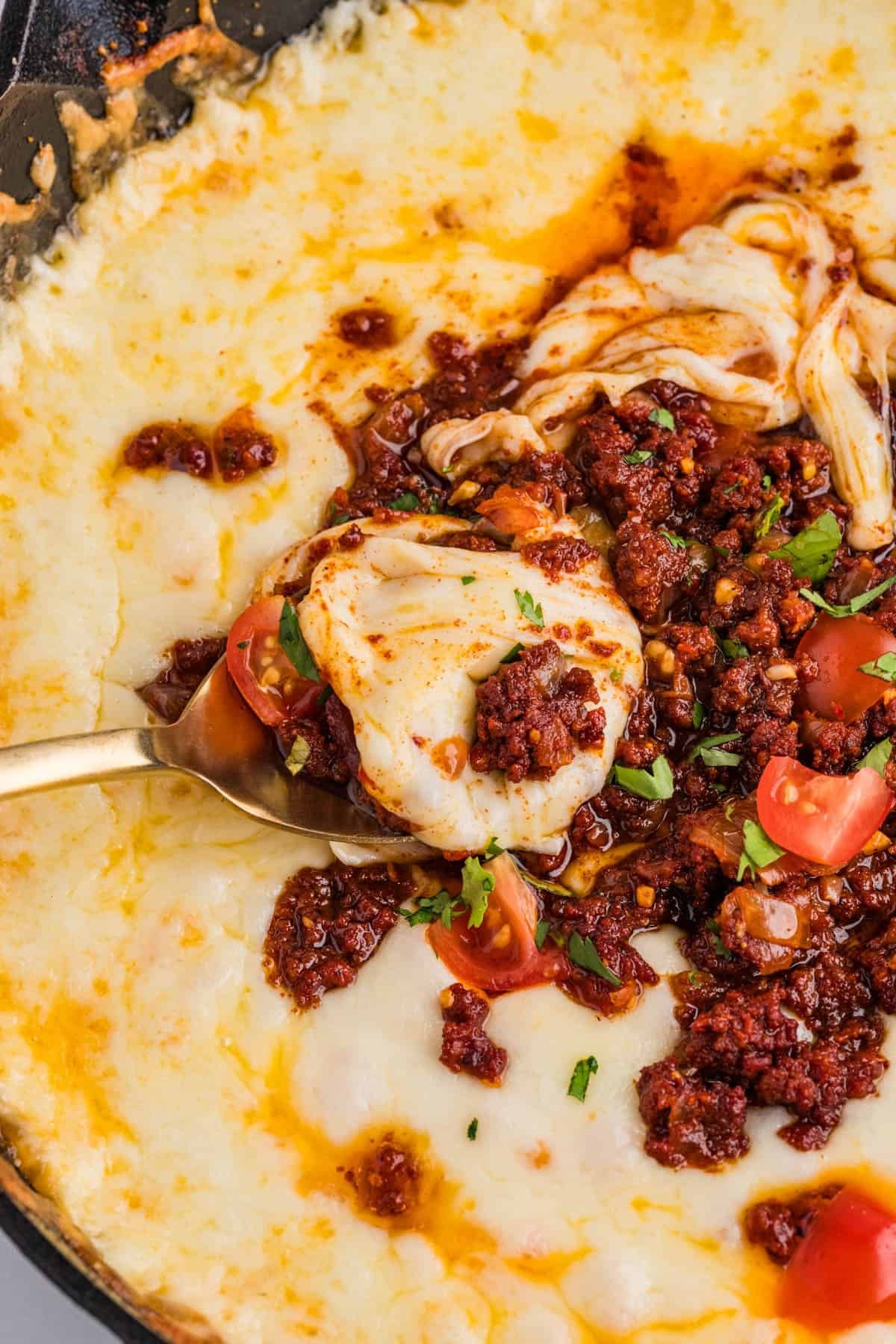 A spoon in melted queso fundido.