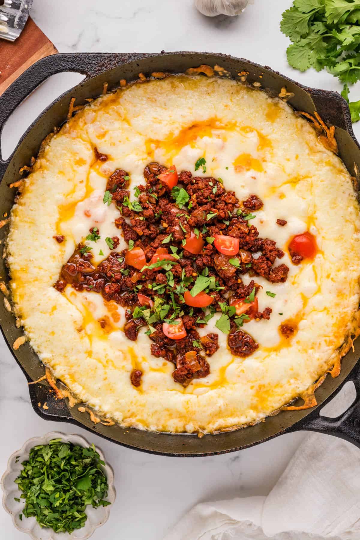 A close up image of a batch of queso fundido with chorizo on top.
